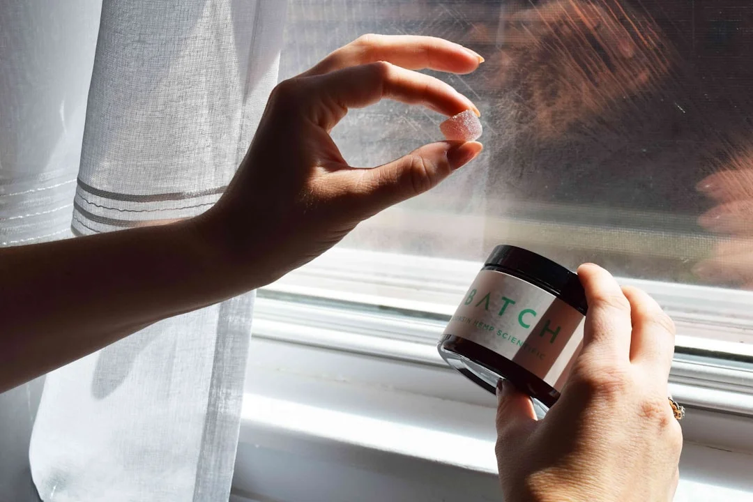 A health-attentive adult comparing two OTC topical ointment tubes on a bright bathroom counter, reading the active-ingredient labels